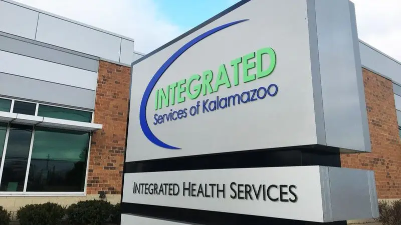 Delante de un moderno edificio de ladrillo y cristal hay un cartel en el que se lee "Integrated Services of Kalamazoo" e "Integrated Health Services".